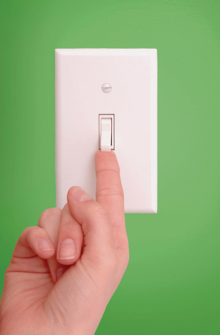 Hand with finger extended to touch bottom of light switch