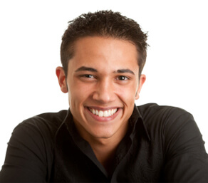 Young man smiling at camera on white background