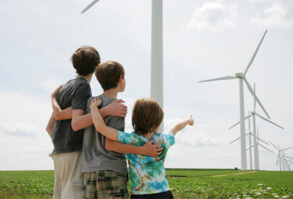 Three young boys looking at windmill farm