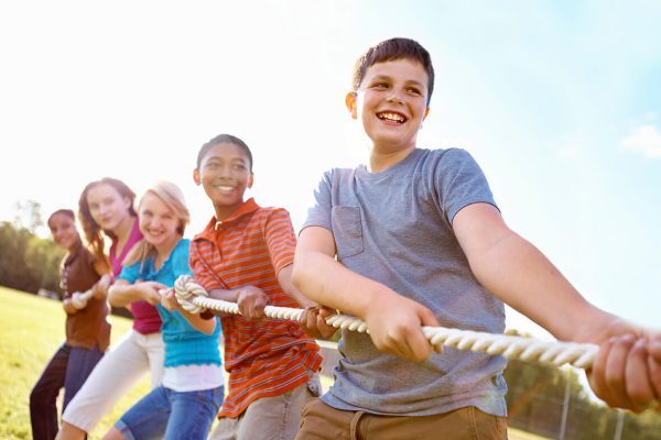 Group of preteens holding rope in tug of war
